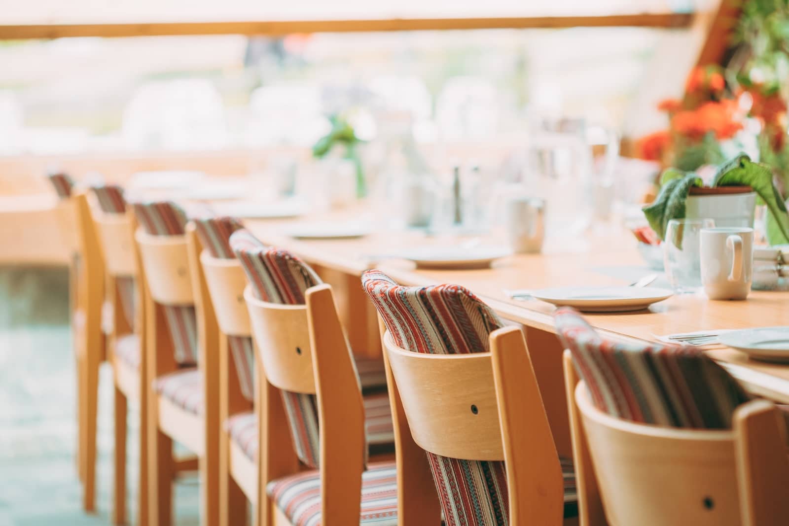 Cozy Interior Of Summer Cafe. Jug Of Water On Table And Cutlery Laid Out